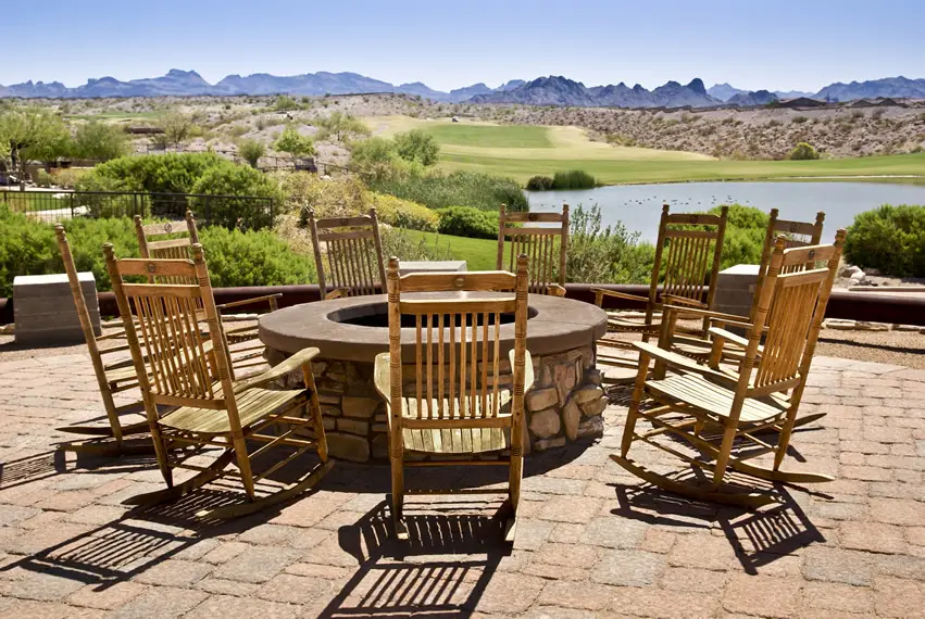 Rocking chairs around outdoor fire pit with amazing view