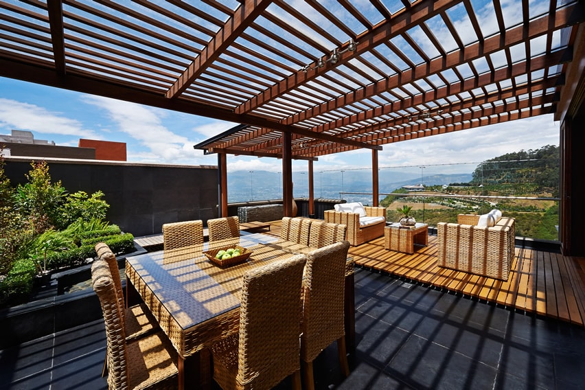 Rooftop deck with wood pergola, outdoor wicker furniture and ocean view