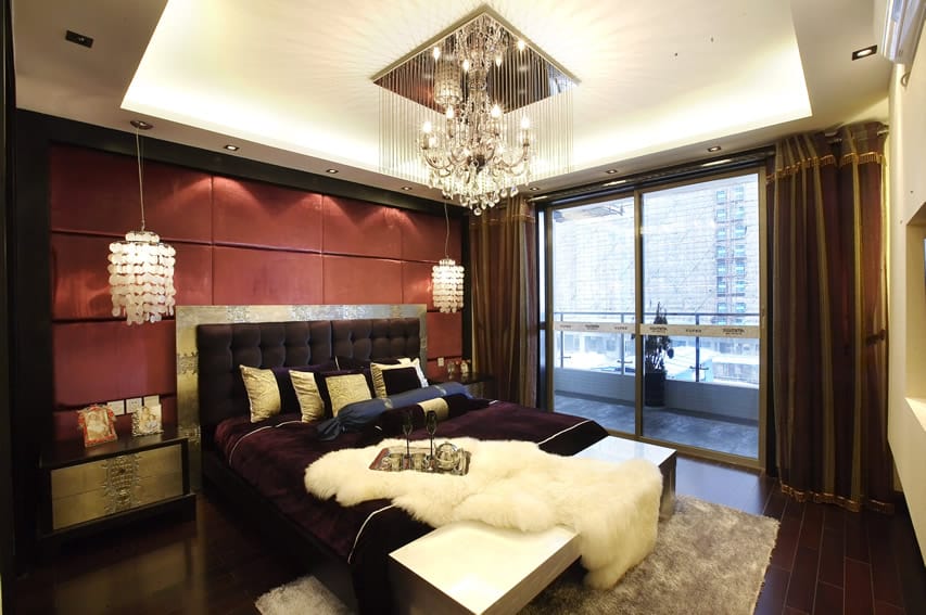 Sleek bedroom with chandelier and balcony