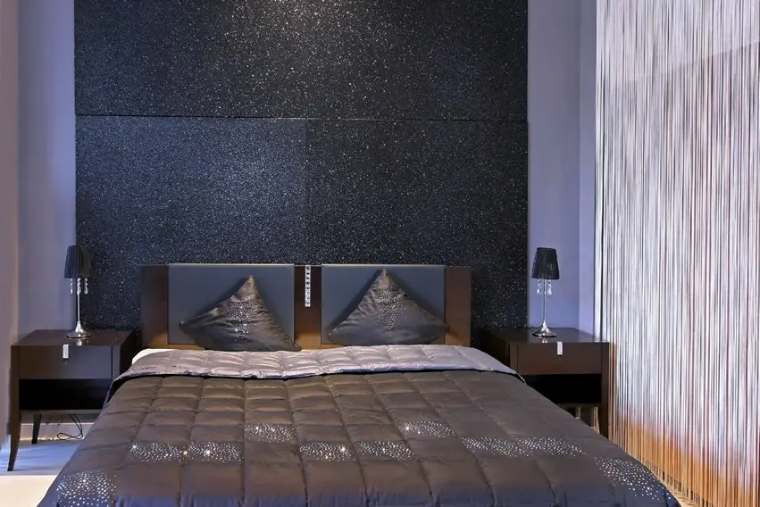 Room with glittery wall panels, two nightstands with lamp and pillows