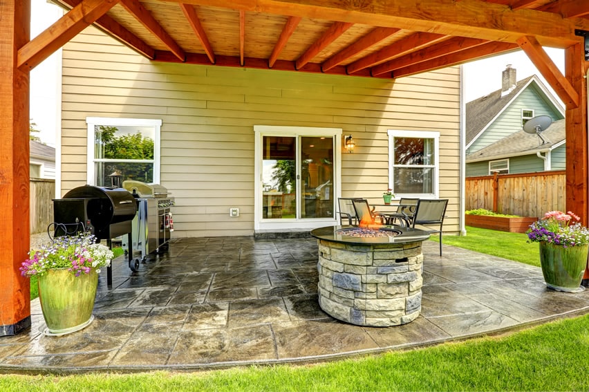 Stone firepit on patio under covered back porch