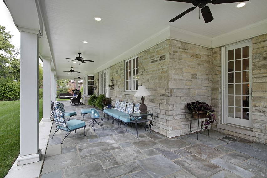 Traditional style covered patio area with wrought iron furniture and ceiling fans