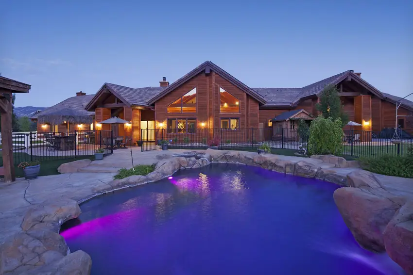 Pool with purple underlight and ranch style house