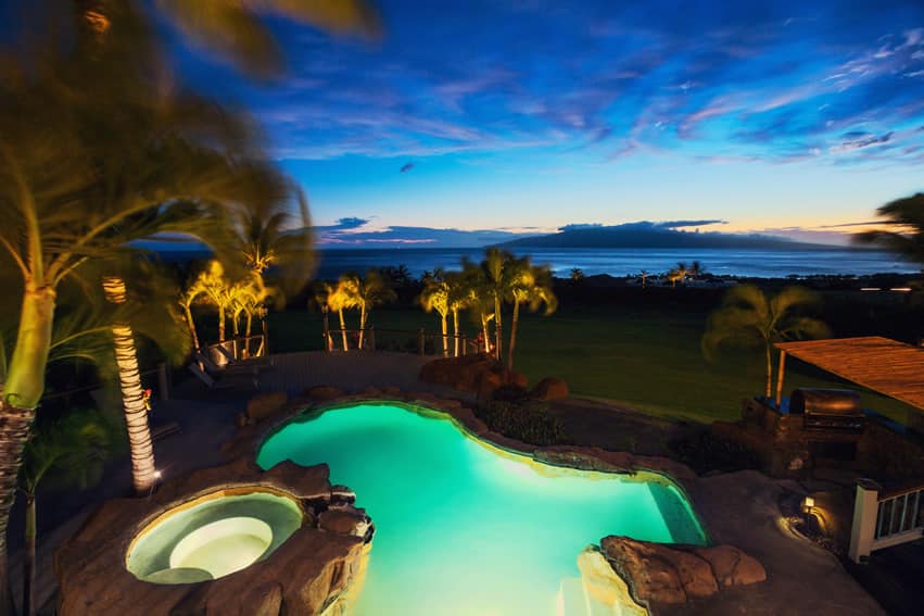 Swimming pool and spa with ocean view at night