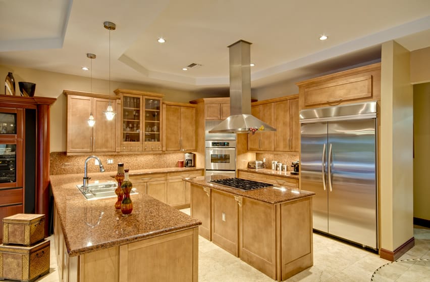 Luxury kitchen with both an island and a peninsula, travertine floors and stainless steel appliances