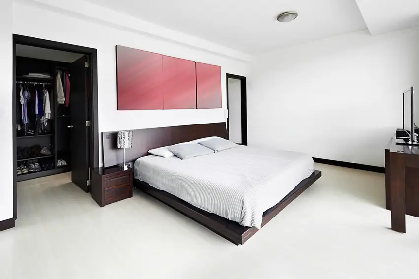 Bedroom with red wall art, dark wengue wood frames and white floors