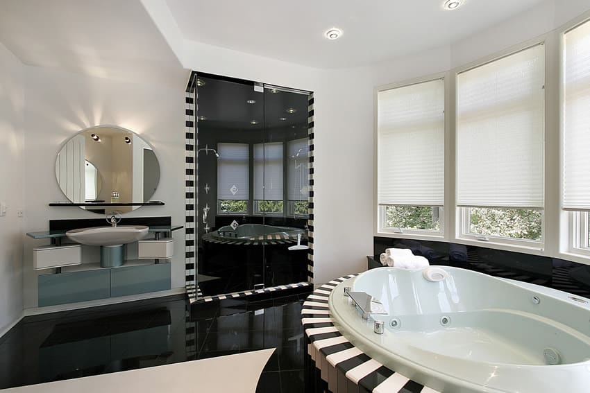 Bathroom with round tub, wraparound windows with shade and black enclosed shower