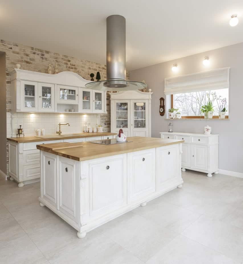 Stylish tuscan white cabinet kitchen with large wood butcher block island