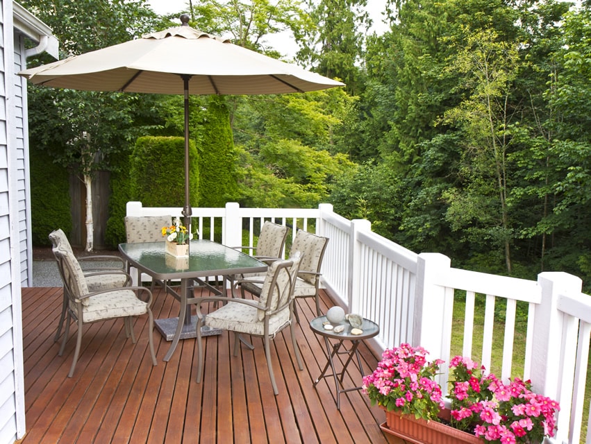 Wood deck with white railing posts and umbrella