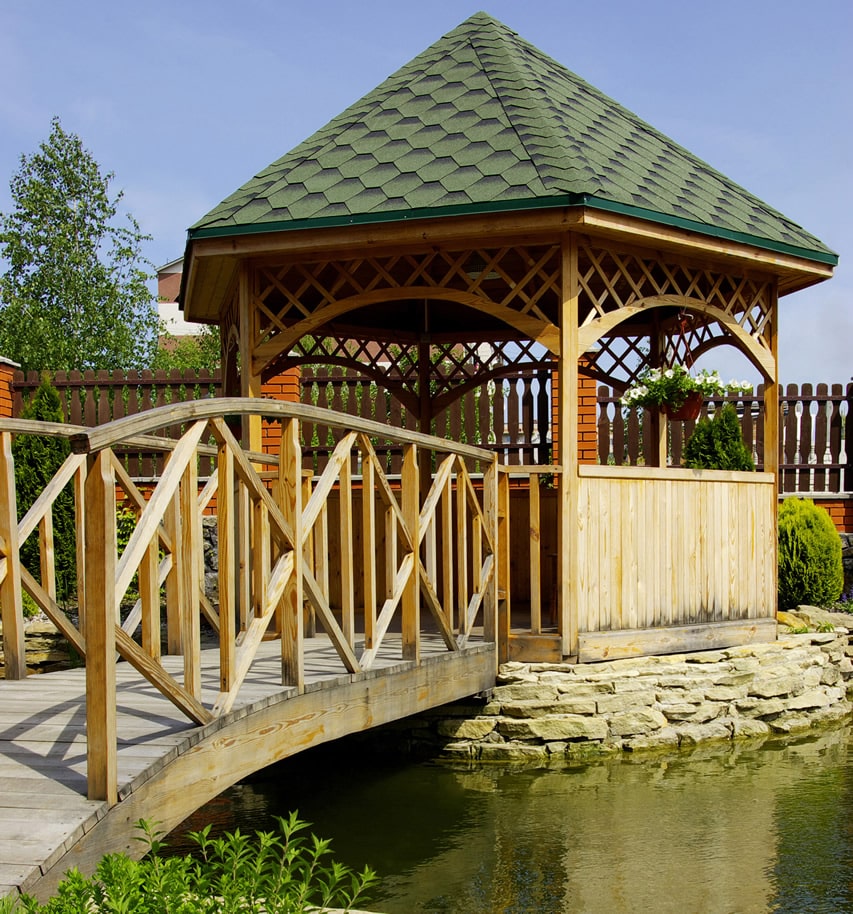 Wood gazebo across pond bridge