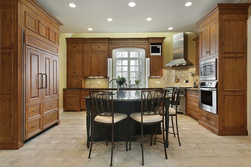 Floor tiling in running bond pattern, pale yellow walls and stools with white cushions