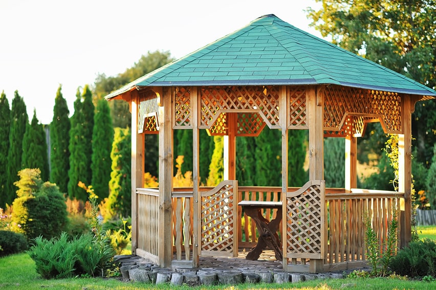 Wooden lattice gazebo with green top