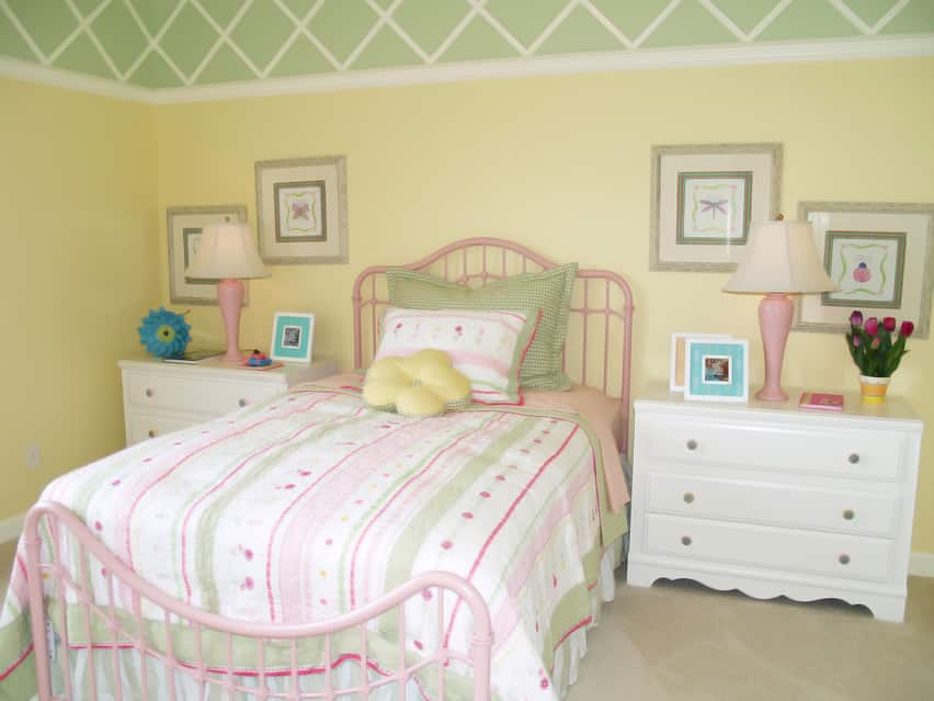 Room with green and yellow walls, pink lampshades and white furniture