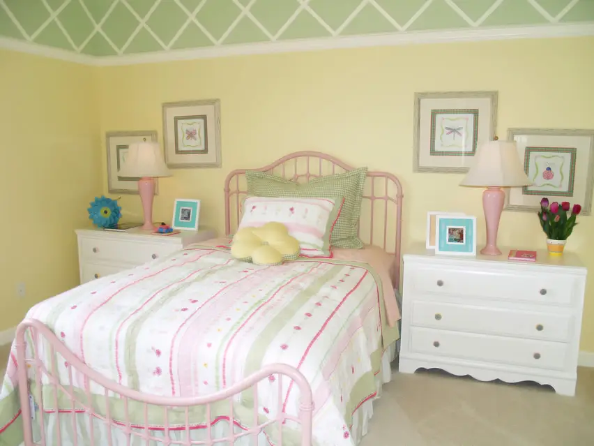 Colorful girl's bedroom with green and yellow walls and white furniture
