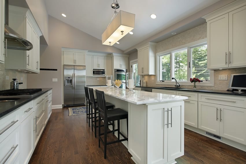 Attractive kitchen with white cabinets and marble island