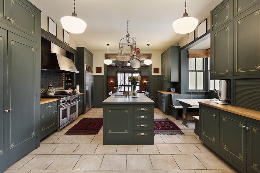 Kitchen with dark green cabinets, wood counters and breakfast bar nook