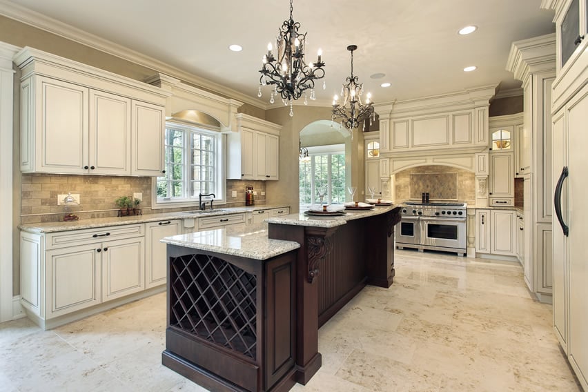 White luxury kitchen with granite island and two chandeliers