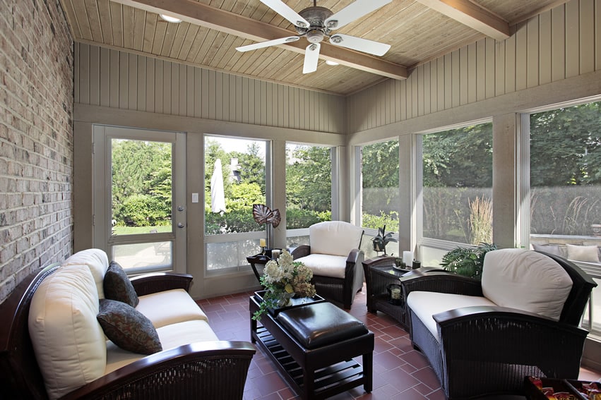Attractive sunroom with exposed beams, brick wall and fan