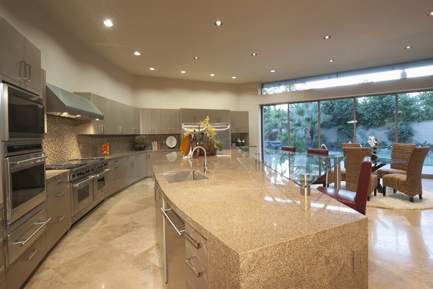 Large kitchen with custom waterfall island with curved design