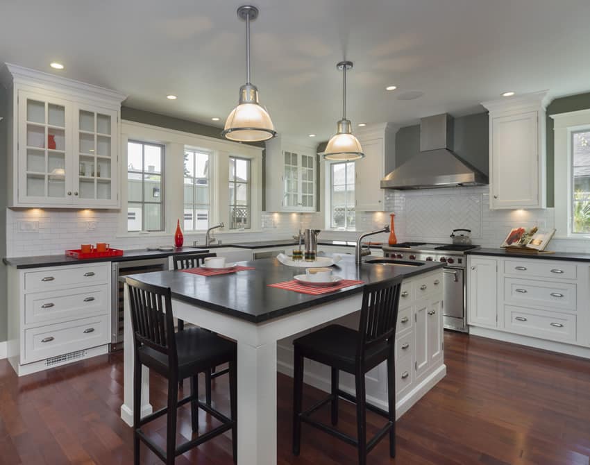 White cabinetry, black chairs and pendant lights