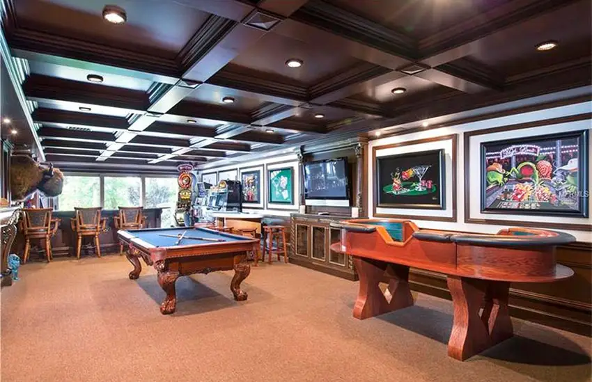 Game room with a bar, lot machines and craps table and coffered ceiling