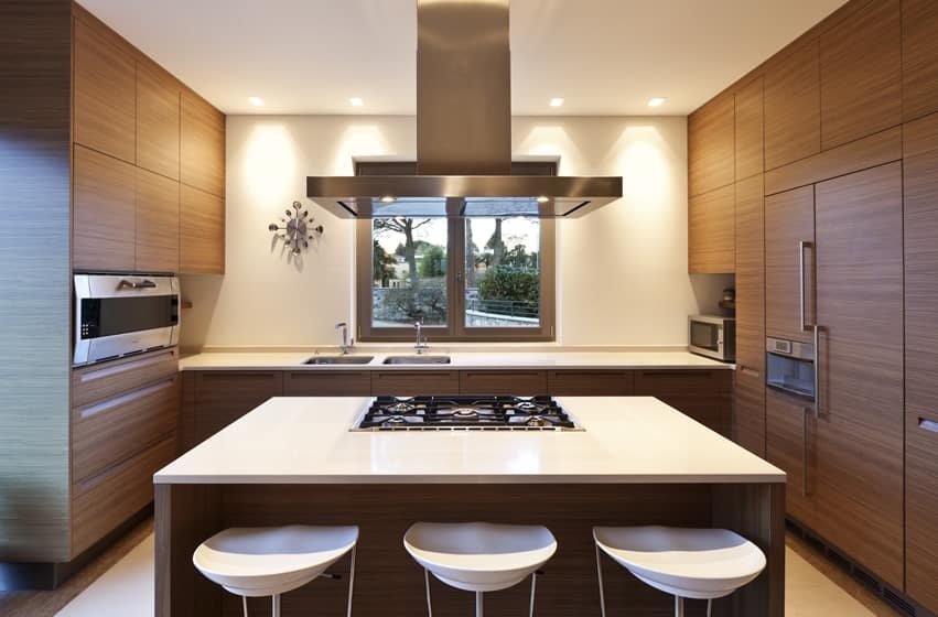 Stylish solid surface countertop with built in cooking hob and white modern barstools