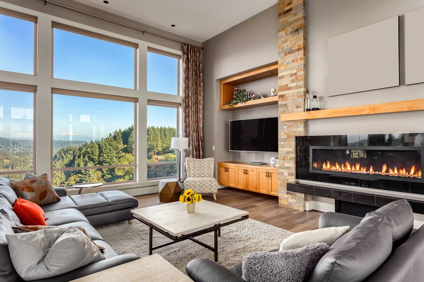 Room with TV, grey sectional and wide windows