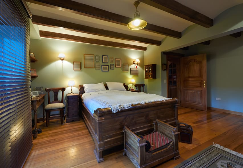 Bedroom with exposed beams and large wood frame bed