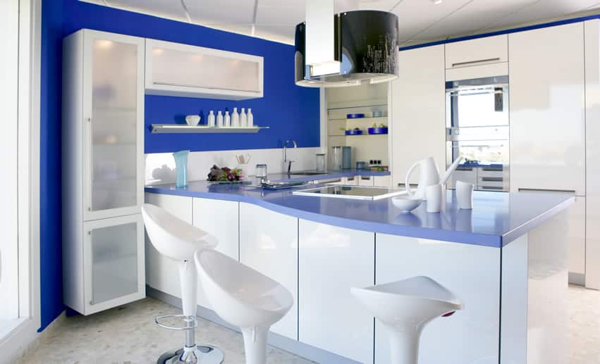 Kitchen with blue accent wall and counter and tall cabinet with frosted cover