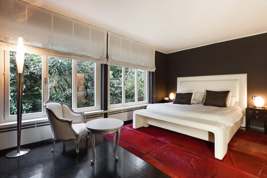 Bold bedroom design with large red rug and modern bed frame