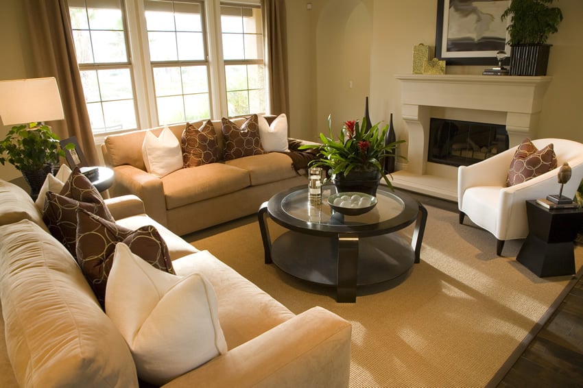 Table with circular metallic framing and glass top and white fireplace