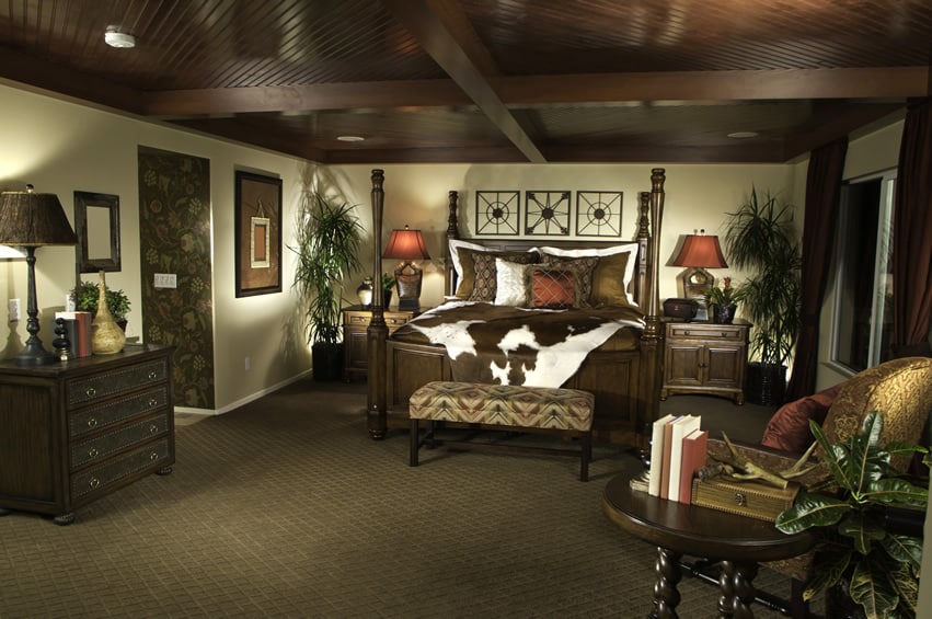 Dark wood ceiling bedroom with cow hide covered bed