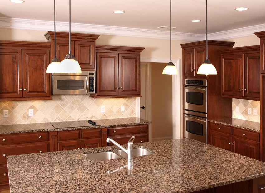 Kitchen with beechwood cabinets with beige Tuscan backsplash tiles