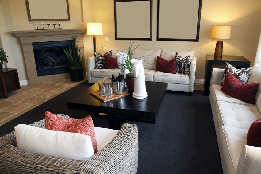 Room with black painted table, wicker chair and travertine floors