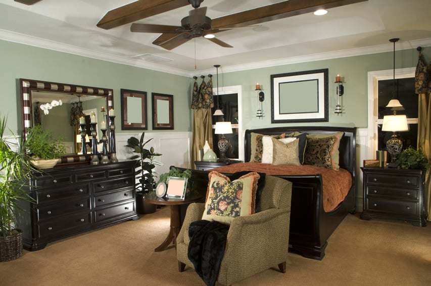 Designer decorated bedroom with wood sleigh bed and matching furniture
