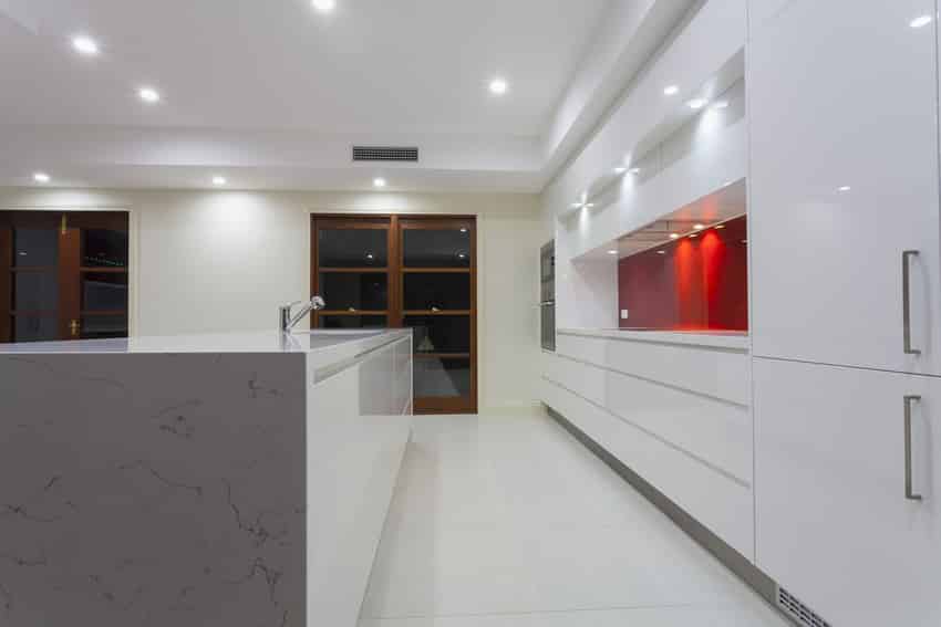 Double line kitchen in white with red accent splashboard