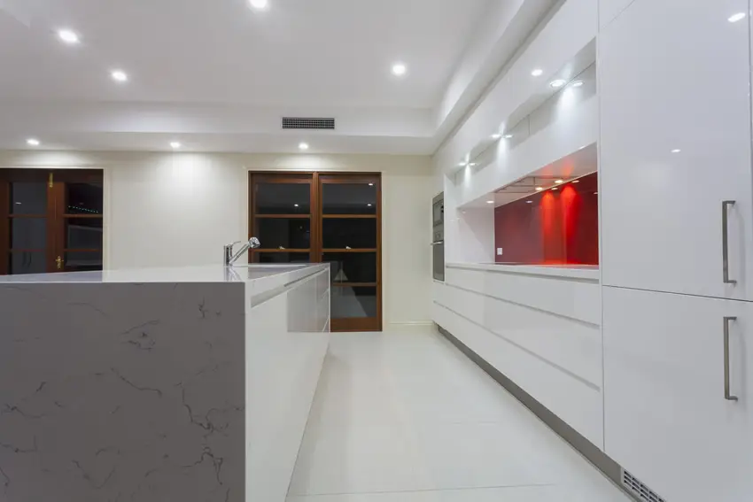 Double line kitchen in white with red accent back splash