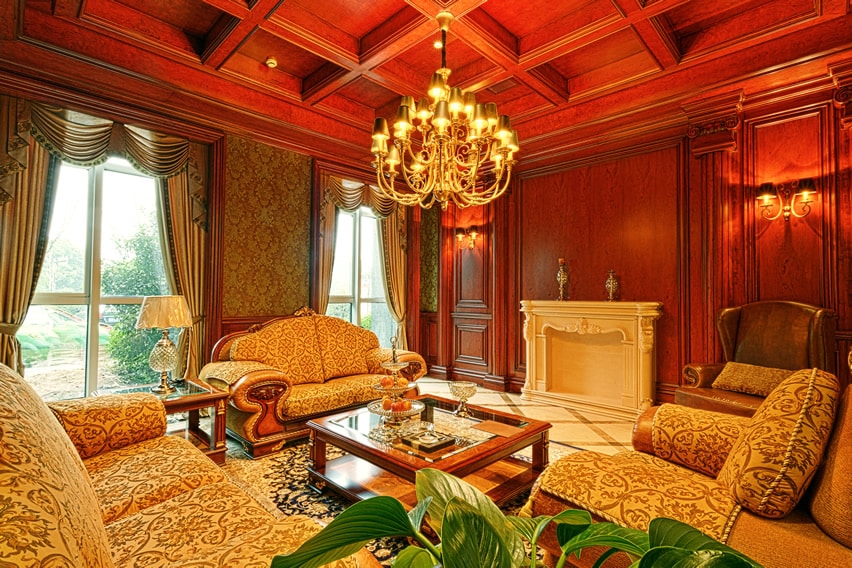 Room with cherry wood walls, white fireplace and coffered ceiling