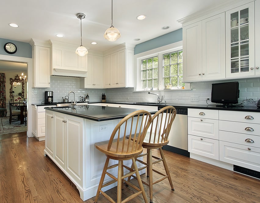 Kitchen with two spindle chairs and cabinets with paneling details