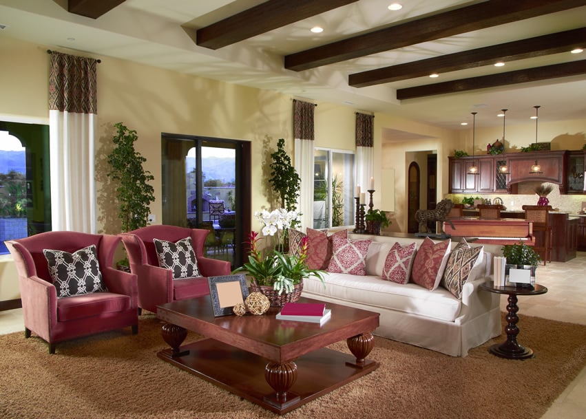 Room with exposed wood beams and maroon accent chairs