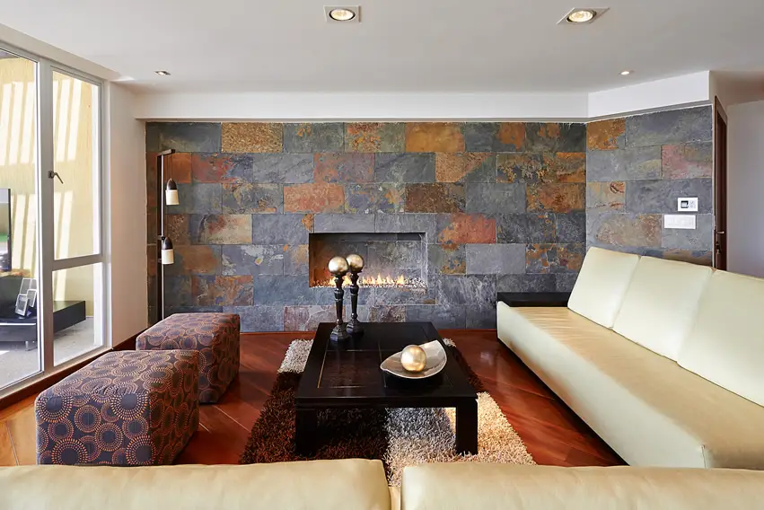 Room with matte stone tiles on the walls and long beige sofa