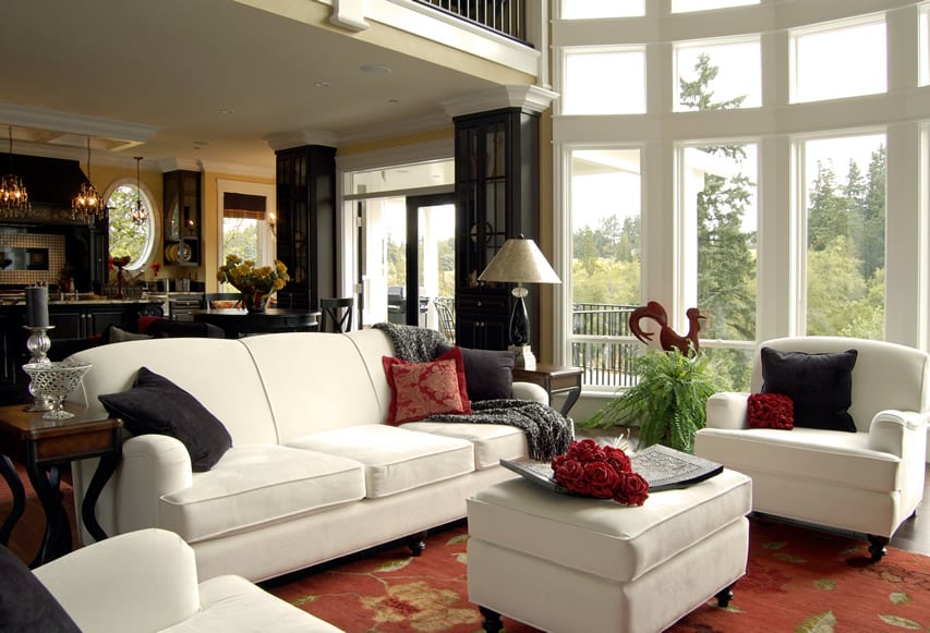 White sofa set with red and gold carpet and tall ceilings