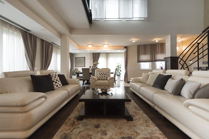 Room with two leather couches, table in wenge and dark ceramic floor tiles