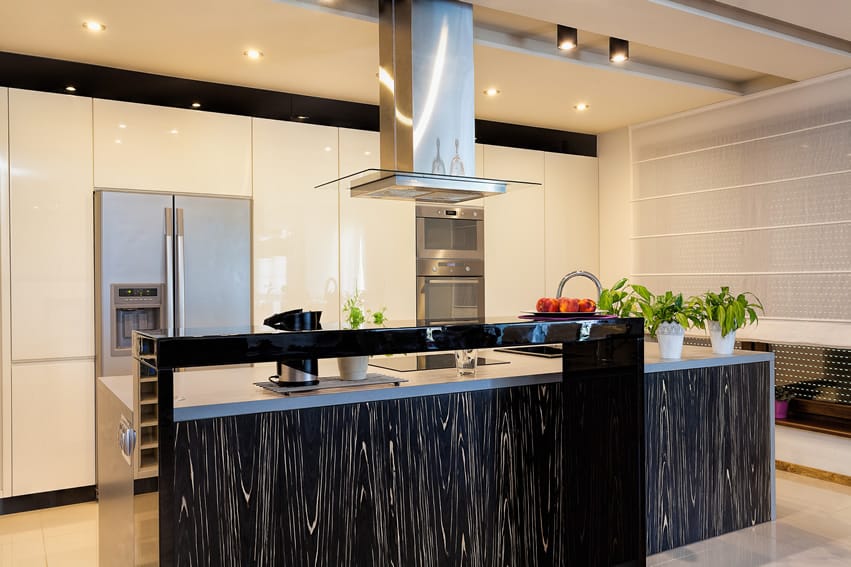 Kitchen island with streaked design, built in appliances and black glossy cabinets