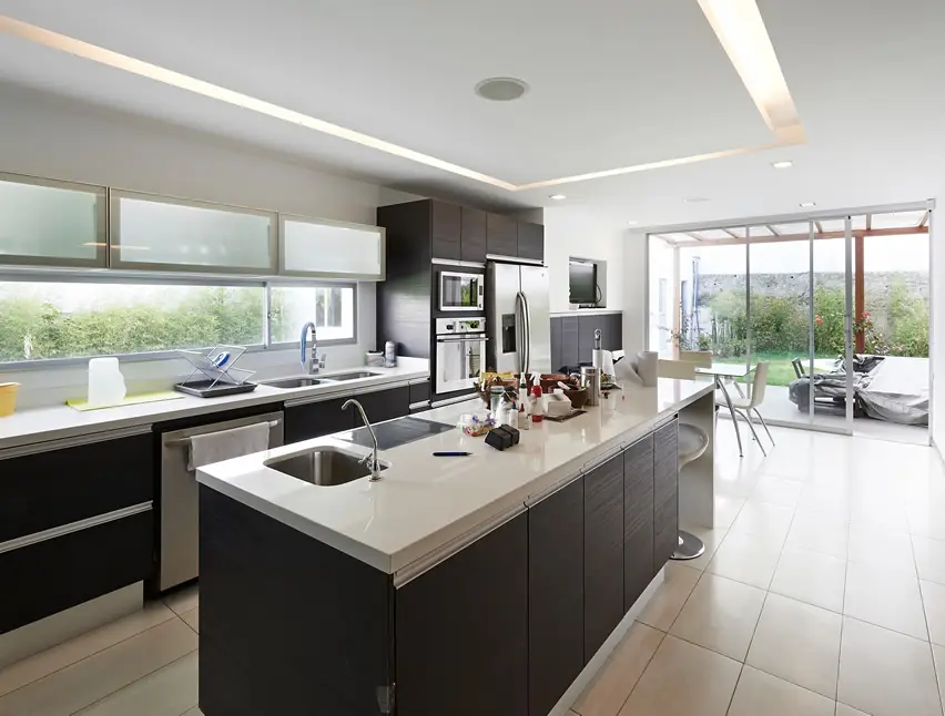 Modern kitchen with long rectangular island and slider door to garden