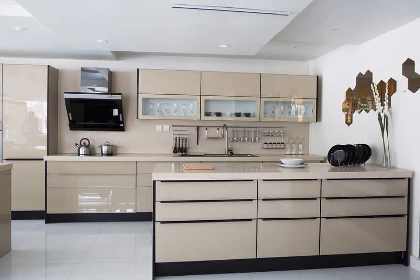 Kitchen with taupe colored cabinets, white flooring and hanging utensils