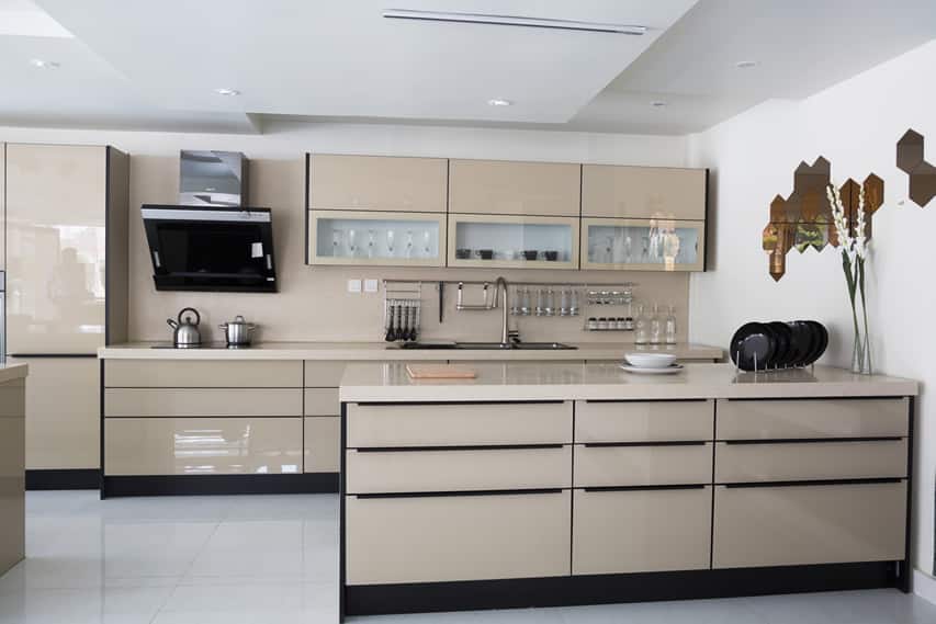 polished tan modern kitchen with glass front cabinets