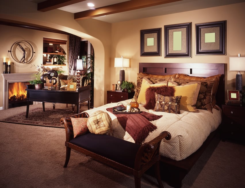 Refined bedroom with fireplace and exposed wood beams