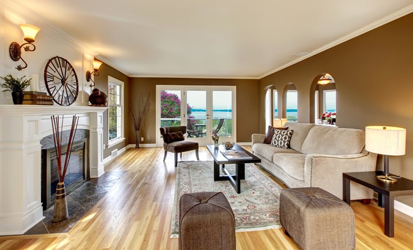 Room with earthy brown ottoman, brown walls and decor on mantel