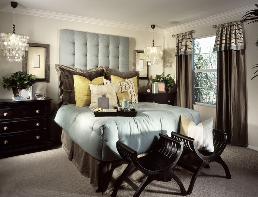 Richly decorated bedroom with blue upholstered headboard